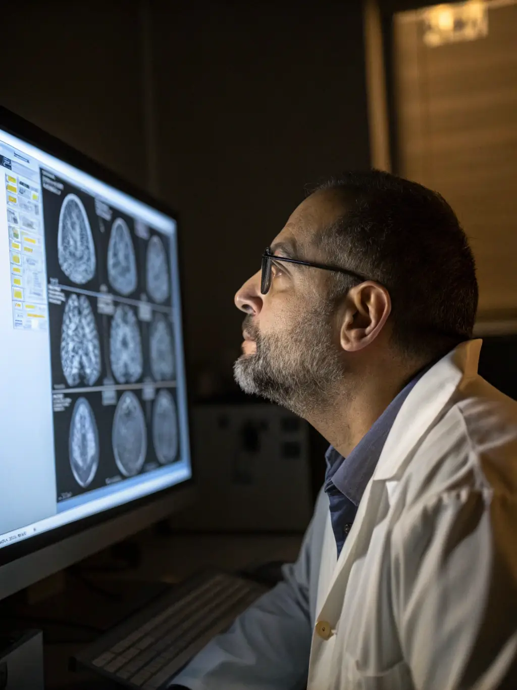 A radiologist reviewing a CT scan remotely, highlighting areas of interest for cancer treatment planning, in a modern, well-lit office setting.